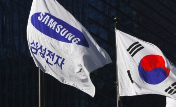 A Samsung flag (L) and South Korean national flag flutter outside the